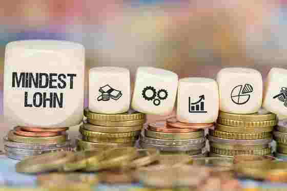 Münzen und Würfel mit Symbolen und Beschriftung Mindestlohn