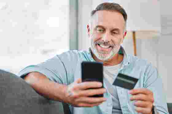 Mann mit Smartphone und Kredikarte