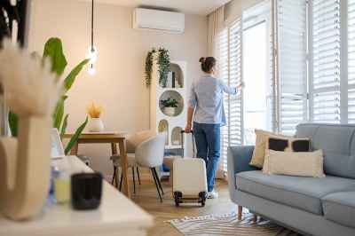 Frau öffnet Fenster in Wohnung