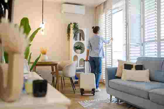 Frau öffnet Fenster in Wohnung